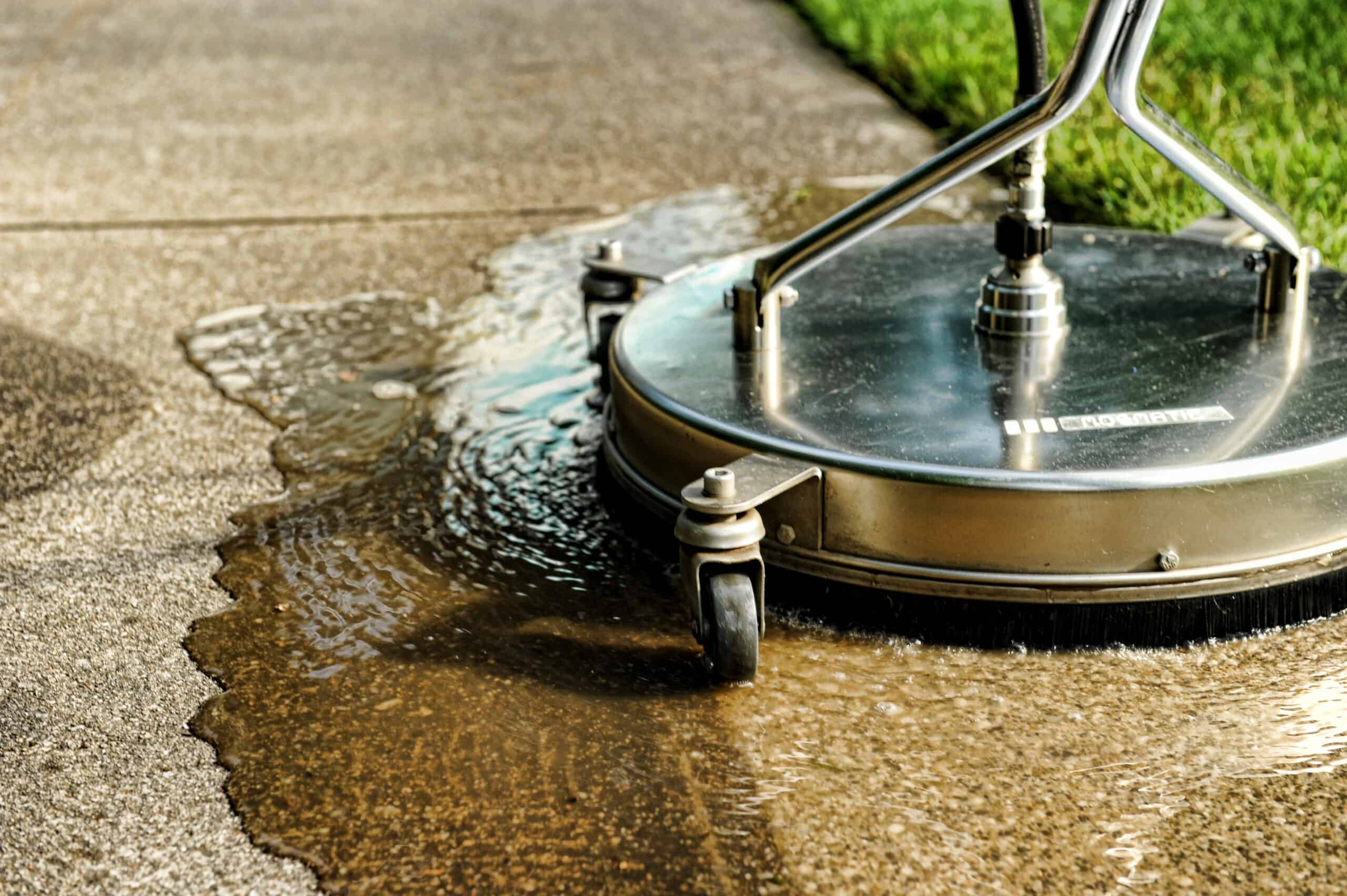 man pressure washes driveway with pressure washer surface cleaner